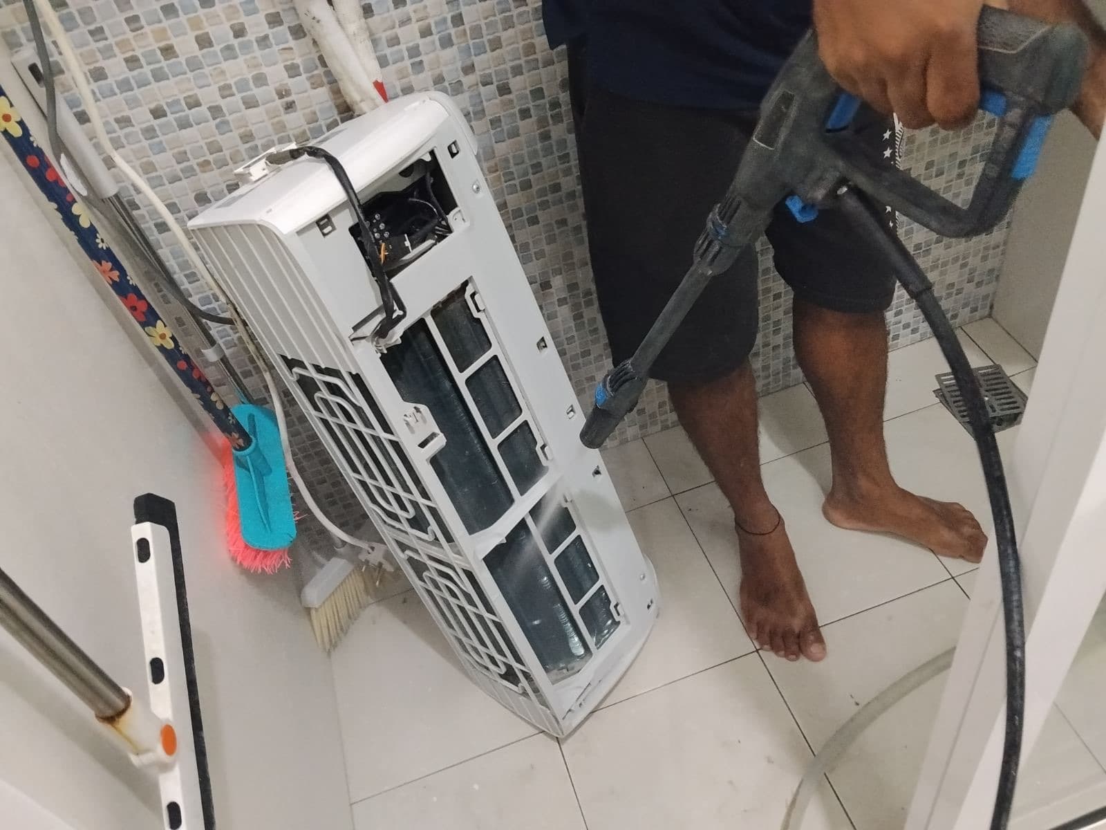 Rishthaa technician thoroughly cleaning a split AC indoor unit