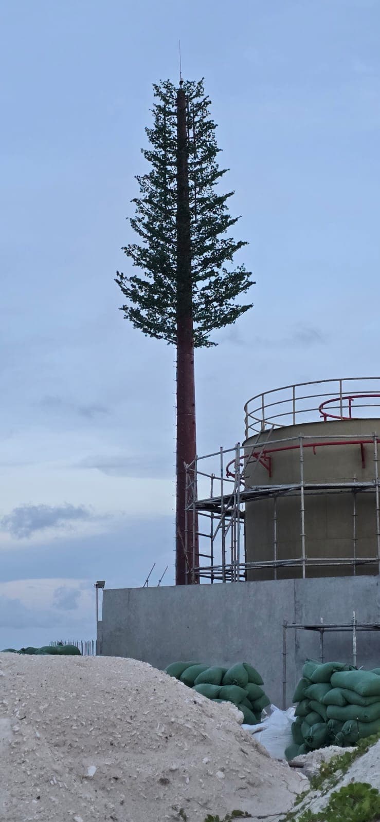 Telecom tower beside a water tank under construction
