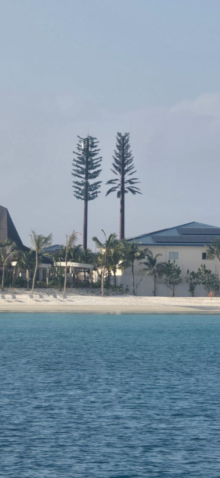 Twin camouflaged telecom towers seen from the lagoon