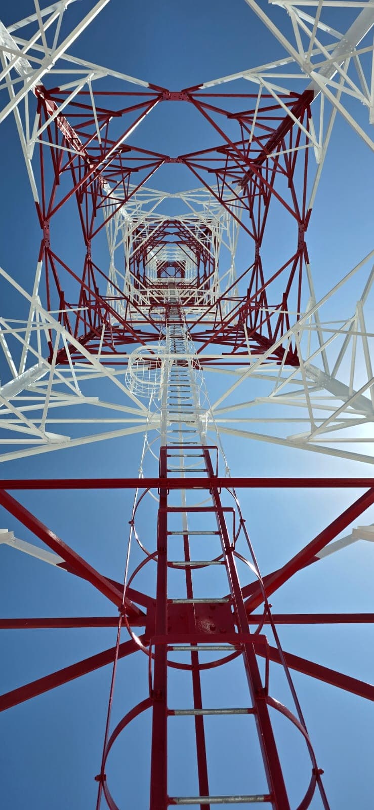 Looking up through a lattice telecom tower