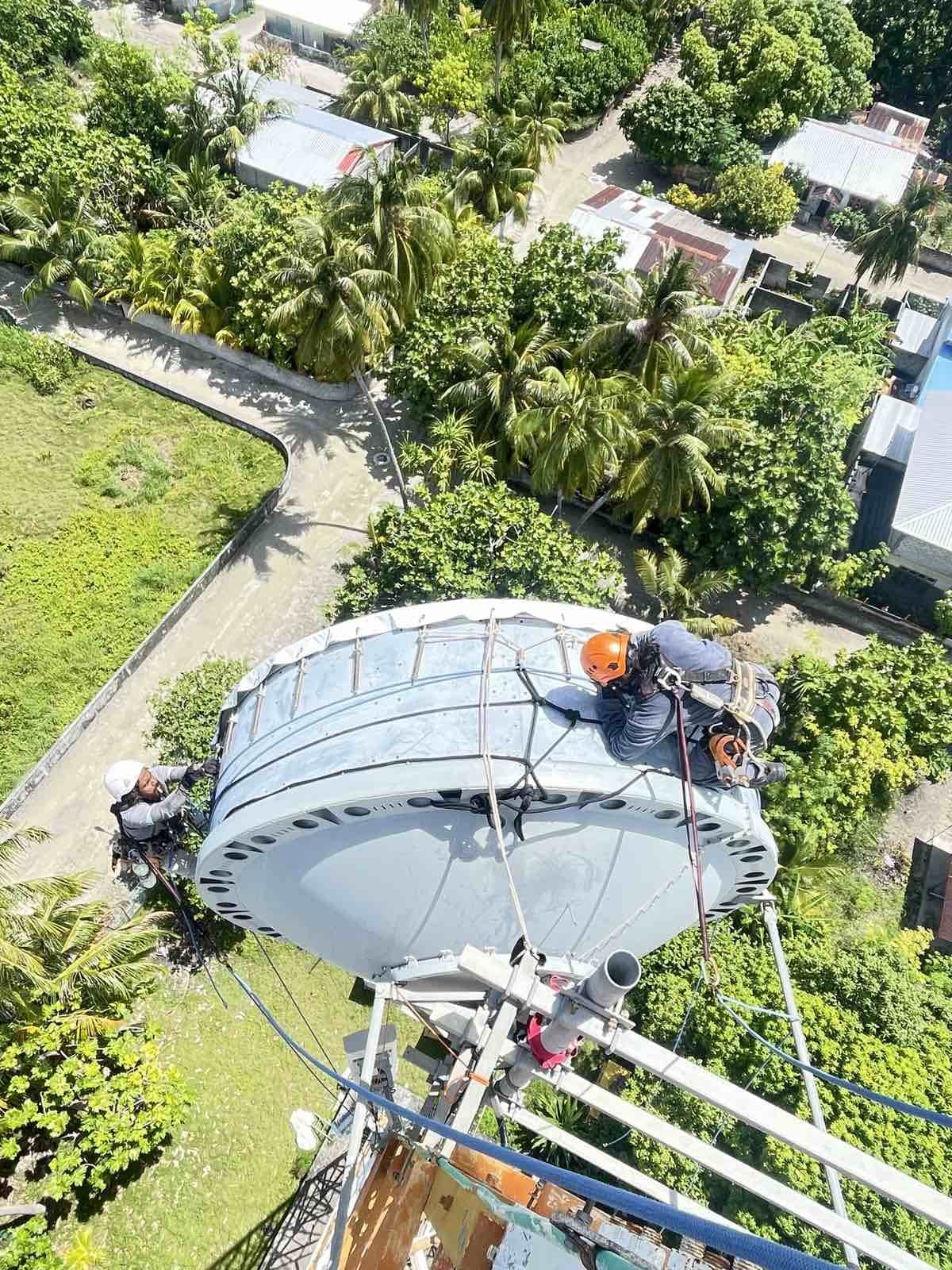 Rishthaa technician on rope access above a Maldivian beach