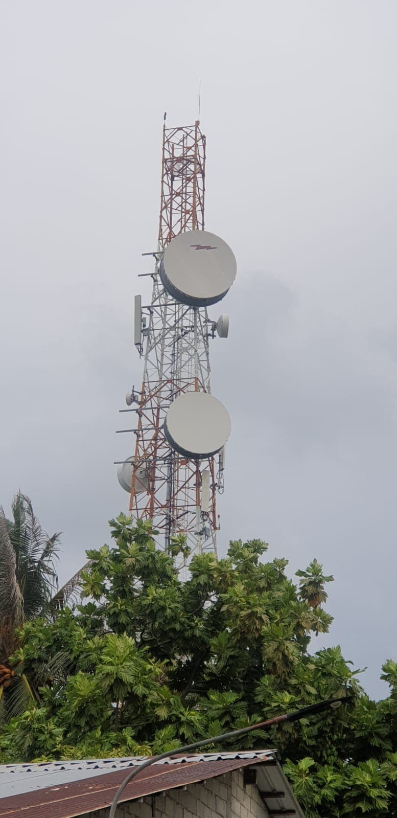Lattice telecom tower with microwave dishes