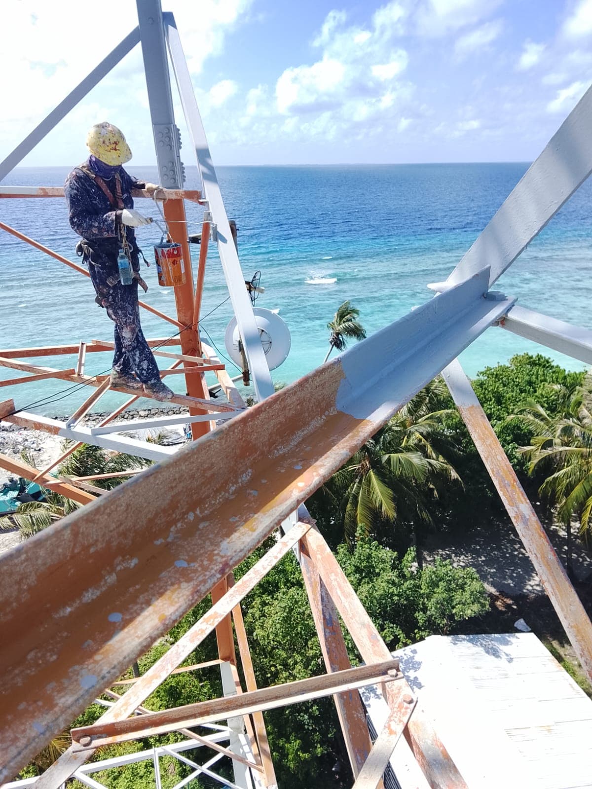 Rishthaa painter on a tower platform over the lagoon