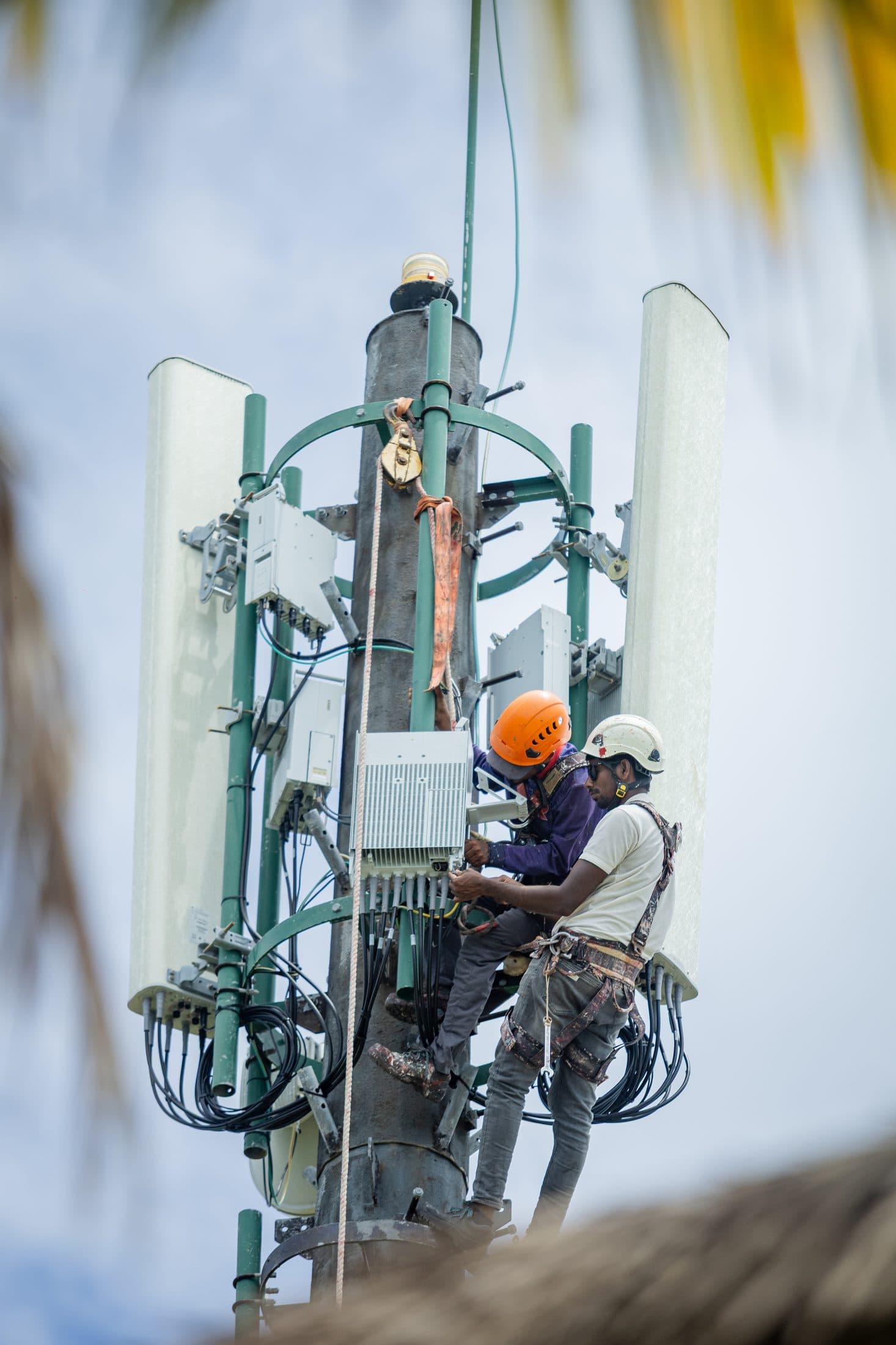 Close-up of Rishthaa technicians working on a telecom tower